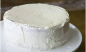 Далее смажьте оставшимся творожным кремом верх и бока торта.