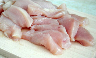 Куриное филе промойте, обсушите салфеткой и нарежьте поперек мышечных волокон небольшими кусочками. Посыпьте их солью с черным перцем.