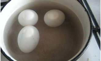 Куриные яйца помойте, залейте холодной водой, добавьте чайную ложку соли и поставьте вариться. Варите яйца после закипания не более 10 минут. Затем слейте воду и залейте яйца холодной водой.