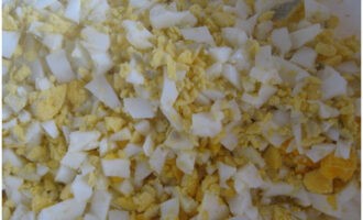 Вареные яйца очистите от скорлупы, мелко нарежьте или так же натрите на терке.