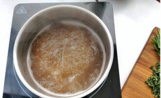 Процеженный говяжий бульон перелейте в кастрюлю и проварите в нем рисовую лапшу в течение 3 минут.