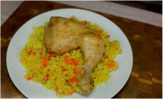 Через полтора часа у вас на столе будет яркое, ароматное горячее блюдо из риса и курицы. Раскладывайте его на порции и подавайте к ужину. Приятного аппетита!