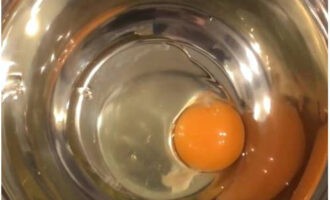 Пышные оладьи на кефире готовятся очень просто. В посуду для замеса теста разбивается одно яйцо.