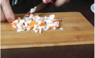Как приготовить простой и вкусный салат на праздничный стол? Крабовые палочки освободите от упаковки и нарежьте небольшими кубиками.