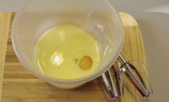 В чашу отправляем куриное яйцо, оливковое масло и молоко – взбиваем миксером на большой скорости до образования пенки.