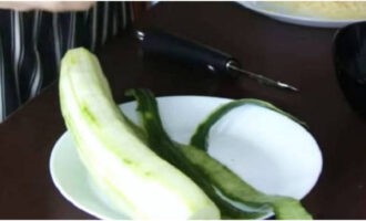 Огурцы промойте, обсушите и с помощью овощечистки снимите кожуру, чтобы получились ленты для декора.