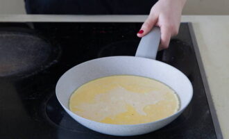 Как только масло начнет пениться, влейте яичную массу. За ручку проверните сковороду по кругу, чтобы масса равномерно распределилась по всей площади. Держите сковороду на огне в течение 6 секунд. 