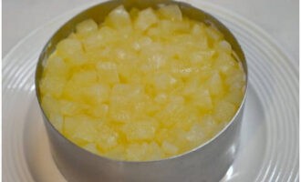 На яичный слой положите нарезанный консервированный ананас, его так же покройте майонезом.