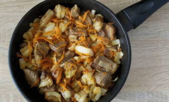 Измельченные овощи добавьте к мясу, перемешайте и жарьте 5-7 минут на умеренном огне.