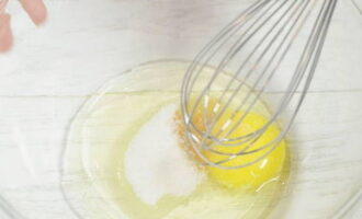 Классические оладьи на кефире готовятся очень просто. В емкость с высокими бортиками разбиваем яйцо и высыпаем ванилин с сахарным песком и солью.