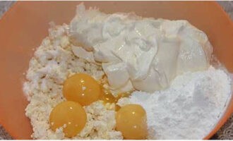 Творожная запеканка в мультиварке готовится очень просто. Разделить яйца на белки и желтки. В посуду для замеса теста переложить, согласно пропорции рецепта творог со сметаной, насыпать крахмал, столовую ложку обычного сахара и добавить желтки.