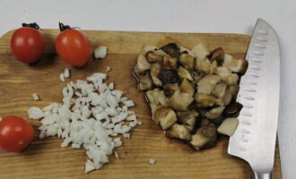Ризотто с грибами готовится очень просто. Первым делом поставим вариться овощной бульон из литра воды, моркови, корня сельдерея, зубчика чеснока и половинки головки лука. Оставшийся лук режем мелким кубиком. Белые грибы размораживаем и так же нарезаем более мелкими кусочками.