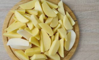 Почистив картошины от кожицы при помощи овощечистки и промыв, делим клубни на дольки средней толщины.