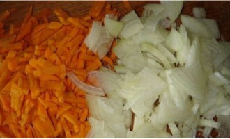 В это время очищаем овощи, нарезаем лук полукольцами, чеснок – пластинами, а морковку натираем на терке.