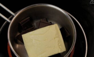 Сливочное масло и кусочки темного шоколада отправляем в сотейник, которые устанавливаем над водяной баней.
