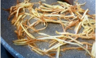Обжариваем соломку картофеля на растительном масле до золотистого оттенка.