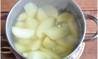 Запеканка с фаршем готовится очень просто. Картофель почистите, хорошо помойте. Затем нарежьте его крупными дольками, залейте водой и поставьте вариться. Воду немного посолите.
