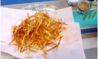 Картофельную соломку выкладываем на бумажные полотенца, чтобы удалить лишний жир.