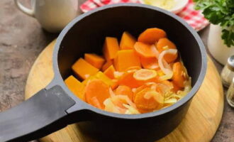 В кастрюлю или сотейник перекладываем обжаренные овощи и кусочки тыквы. Заливаем все это горячей водой.