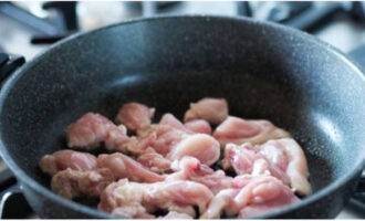 Мясо курицы нарежьте небольшими кусочками и в течение 10 минут обжарьте на разогретом растительном масле.