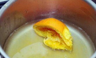 Готовим пропитку. В толстостенном сотейнике соединяем воду, сливочный ликер и выдавливаем сок из половинки апельсина. Разместив на плите, размешиваем и кипятим. Снимаем с огня и даем остыть.