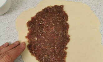На половину каждого пласта выкладываем мясную начинку.