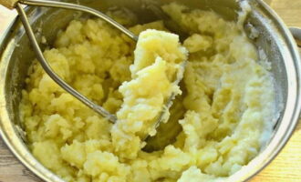 Картофель с молоком и маслом хорошенько разминаем до образования нежного пюре.