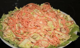 В тарелку для подачи выкладываем капустные листья. На них перекладываем подготовленный салат.
