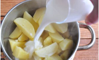 С готового картофеля слейте воду. Положите кусочек сливочного масла и влейте теплое молоко.