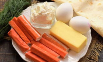 Как приготовить рулет из лаваша с крабовыми палочками и сыром? Подготовим необходимые продукты по списку. Куриные яйца заранее отвариваем и остужаем.