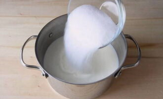 В кастрюле нагреть молоко и растворить в нем половину количества сахара и довести до кипения.