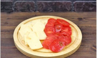 Тонкими пластинками разделываем помидоры и сыр.
