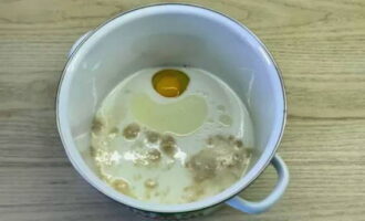 Молоко немного подогрейте и перелейте в посуду для замеса теста. Разбейте к нему яйцо, насыпьте чайную ложку соли, налейте 2 столовые ложки растительного масла и перелейте подошедшую опару. Эти ингредиенты перемешайте.