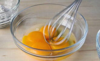 В отдельной посуде венчиком немного взбить яйца с желтком.