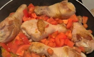 К золотистой курице высыпаем помидоры, перемешиваем и томим 10 минут.