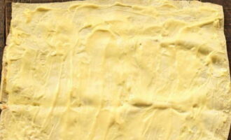 Расстилаем тонкий лаваш на рабочую поверхность. Обмазываем лаваш сливочным плавленым сыром.