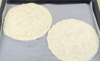 На 4 листах пекарской бумаги рисуем по два круга диаметров 20 сантиметров (удобно обводить тарелку), выкладываем массу равномерным слоем.