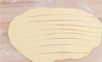 Спустя 15-20 минут тесто раскатываем и разрезам на полоски шириной около двух сантиметров.