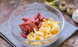 В глубокой салатнице смешайте измельченные ингредиенты: колбасу и твердый сыр.