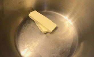 В кастрюлю или сотейник выкладываем кусок сливочного масла и ставим на плиту.