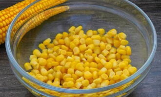 Из консервированной кукурузы сливаем жидкость. Продукт выкладываем в глубокий салатник.