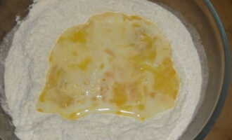 Затем молочно-яичную смесь влейте к муке, вымесите однородное тесто.