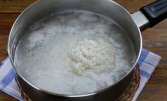 Подготовленный рис промываем и выкладываем в кастрюлю. Заливаем кипящей водой и доводим все это до повторного закипания. Далее варим на слабом огне 20 минут.