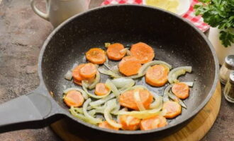 Разогреваем сковороду с растительным маслом и выкладываем на него лук с морковью. Обжариваем около 3 минут, периодически помешивая.