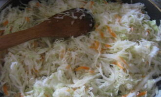 Далее добавьте на сковороду капустную стружку, перемешайте и тушите до готовности овощей 25-30 минут. Помешивайте блюдо лопаткой, чтобы ничего не пригорело.