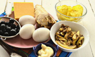 Как приготовить салат «Подсолнух» с чипсами по классическому рецепту? Заранее отварите и остудите куриное филе и яйца. 