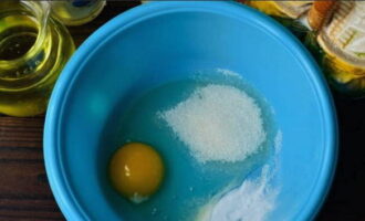 Как приготовить пышные панкейки на кефире? В глубокую емкость разбиваем яйцо и всыпаем сахар и соду.