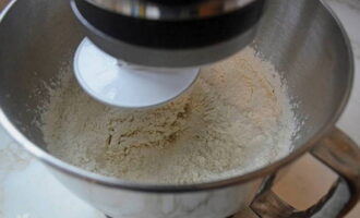В глубокую миску просейте муку и добавьте соль. Тонкой струйкой влейте опару и перемешайте.