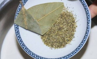 В прогретые сливки отправляем соль, черный молотый перец, сушеные травы и лавровый лист.