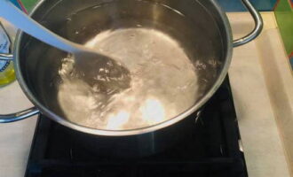В кастрюлю влейте воду и поставьте емкость на плиту. Вода, в которой будет вариться яйцо должна находиться на грани кипения. Когда вода начнет закипать ложкой размешивайте ее по кругу, чтобы в центре образовалась воронка.
